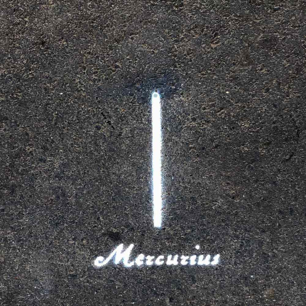 Planet Mercury, 0.5 cm in diameter, painted on the pavement with the Latin name tag Mercurius.